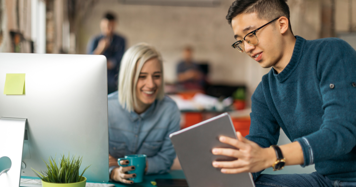 Featured photo of two coworkers looking at a tablet screen