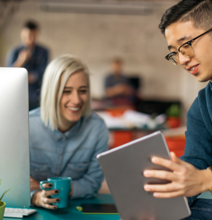 Featured photo of two coworkers looking at a tablet screen