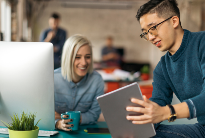 Featured photo of two coworkers looking at a tablet screen