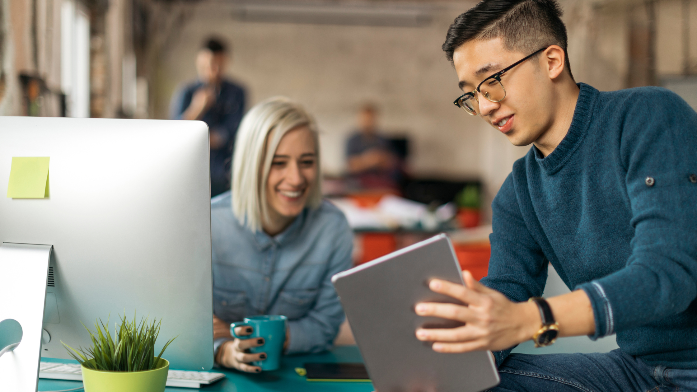 Featured photo of two coworkers looking at a tablet screen