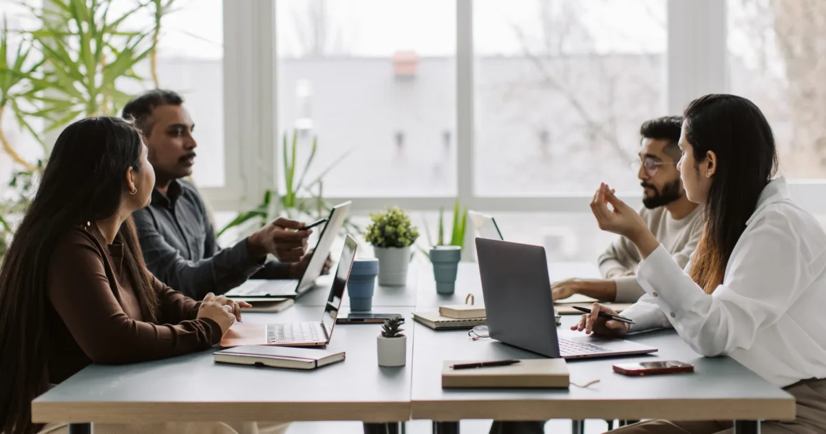 four coworkers talking at the table, working together (1)