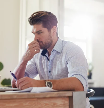 male working from home, looking at laptop screen, thinking (1)