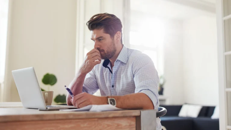 male working from home, looking at laptop screen, thinking (1)