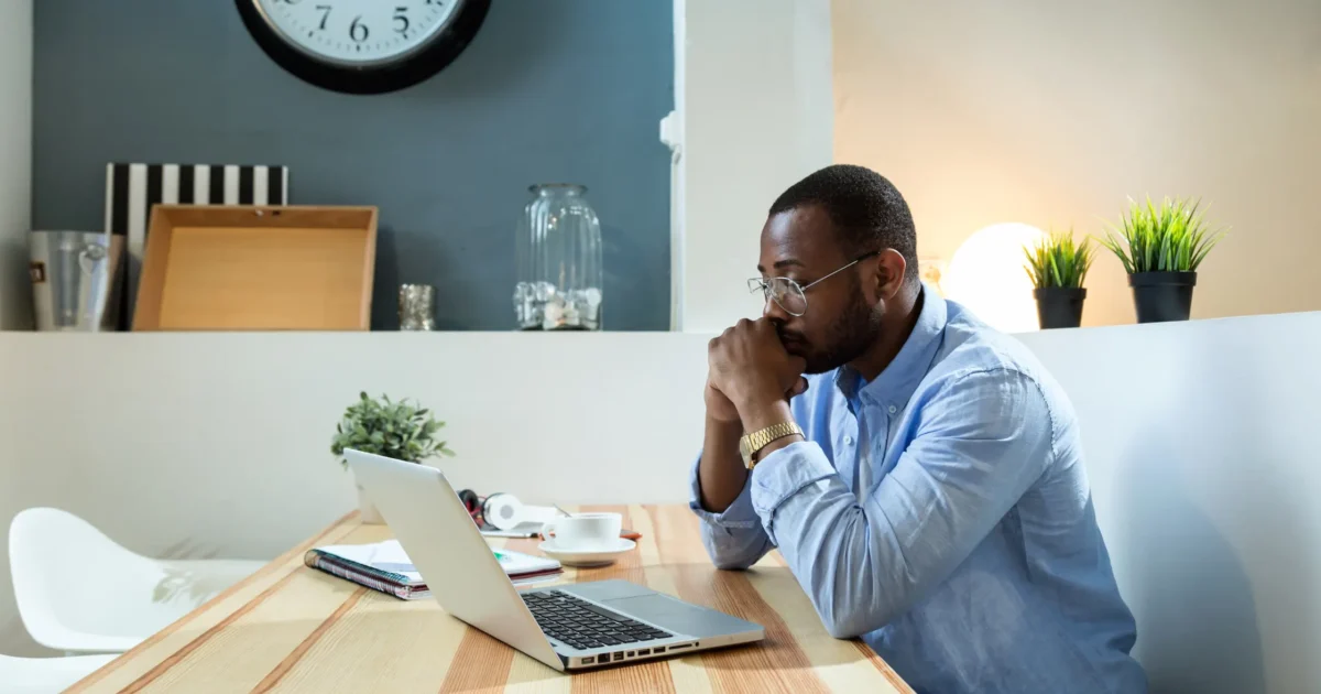 man looking at laptop, deep in thought