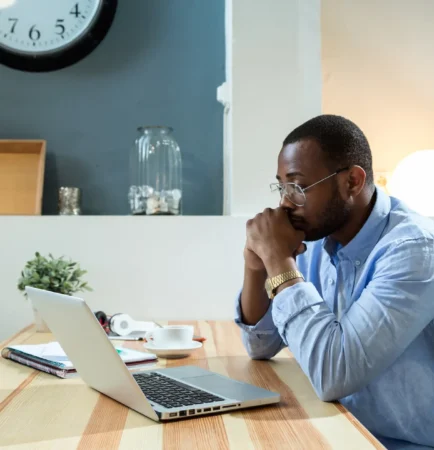 man looking at laptop, deep in thought