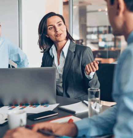 Three coworkers gathered at table in discussion