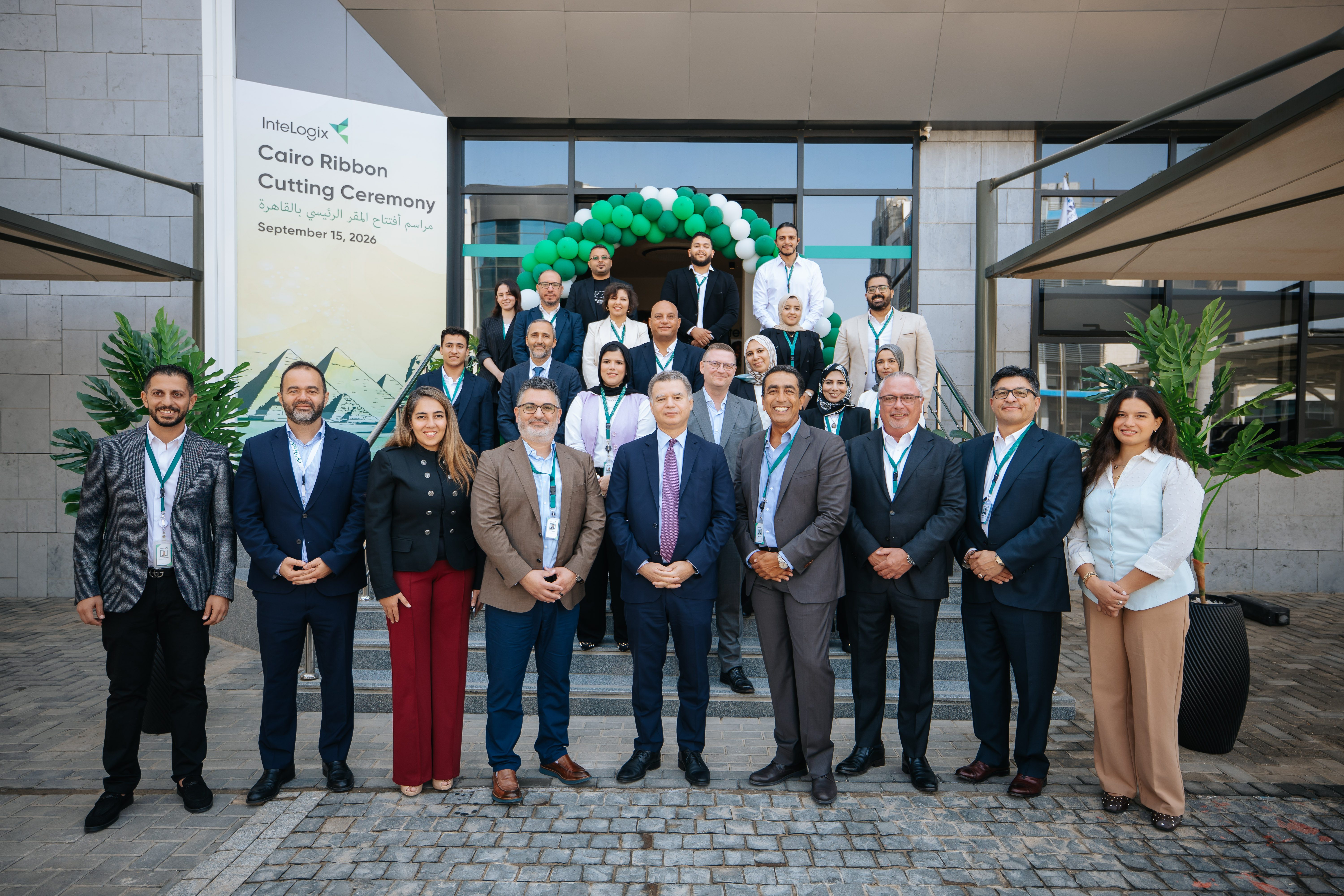 InteLogix and ITIDA leadership gathered on the steps of the new Cairo contact center beneath a green and white balloon arch at the ribbon-cutting ceremony